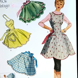 May include: Vintage Simplicity sewing pattern featuring apron designs. The image showcases various apron styles, including a yellow apron with a heart-shaped pocket, a green scalloped apron, and a blue plaid apron. The pattern is labeled "9311".