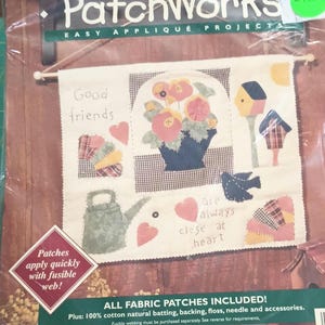 May include: A Bucilla's PatchWorks Easy Applique Project kit featuring a white fabric panel with a floral design, a bird, a watering can, and a birdhouse. The panel has the text "Good friends are always close at heart".
