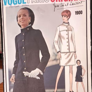 May include: Vintage Vogue Paris Original sewing pattern featuring a woman in a black coat and a white suit. The pattern is designed by Yves Saint Laurent, with the number 1900. The cover includes the name Marilyn Wilson.