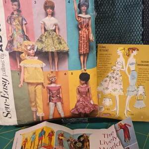 May include: A vintage Barbie doll sewing pattern booklet with six different patterns for doll clothes. The cover features a colorful illustration of Barbie dolls wearing various outfits. The title of the booklet is "Around-the-Clock Wardrobe" and the pattern number is 5756. The booklet is in good condition and appears to be from the 1960s.