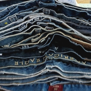 May include: A stack of blue denim jeans with the words "American Eagle" visible on the fabric.