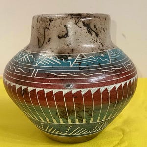 May include: A white ceramic mug with a black handle and the text "But First, Coffee" in a black, bold font. The mug is sitting on a wooden surface. The mug is 4 inches tall.