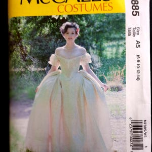 May include: McCall's Costumes sewing pattern featuring a woman in a cream-colored off-the-shoulder gown. The pattern packet is labeled M7885, size A5 (6-8-10-12-14). The image has a yellow and green color scheme.
