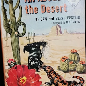 May include: A book cover with the title "All About the Desert" by Sam and Beryl Epstein. The cover features a colorful illustration of a desert landscape with a cactus, a skunk, and a lizard.