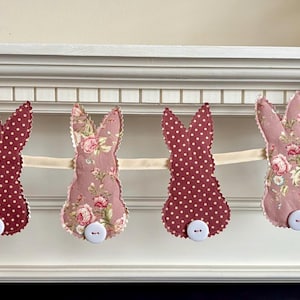 May include: A handmade wooden sign displaying the word "Welcome" in a whimsical font. The sign has a distressed white backdrop and a dark stained wooden frame, ideal for adding rustic charm to a doorway.