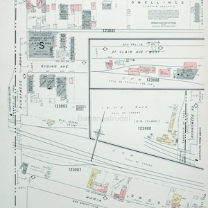 Peut inclure: Une carte en noir et blanc d'un pâté de maisons avec des noms de rues, des numéros de bâtiments et des limites de propriété. La carte montre l'emplacement d'un dépôt ferroviaire et des bâtiments environnants. La carte est intitulée "Toronto, Vol. 12, Février 1904."