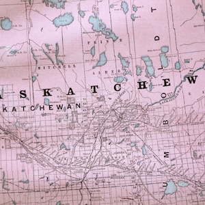 May include: A vintage map of Saskatchewan, Canada, showing the names of towns and cities, including Prince Albert, Saskatoon, and Regina. The map is printed on pink paper and shows the location of lakes and rivers.