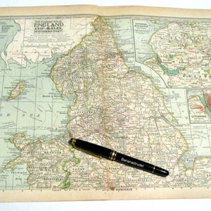 May include: A vintage map of England and Wales, showing the southern part of the country. The map is printed on cream-coloured paper and has a grid pattern. A black pen is lying on the map.