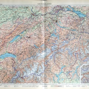 May include: A vintage map of Switzerland from The Times Atlas, showing the country's geography, including lakes, rivers, and mountains. The map is printed in shades of blue, green, and brown, with red lines indicating roads and railroads. The scale of the map is 1:1,750,000.