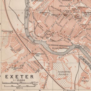 Könnte beinhalten: Eine Vintage-Karte von Exeter, England, die die Straßen, Sehenswürdigkeiten und Wasserwege der Stadt zeigt. Die Karte ist in Rosatönen und Braun gedruckt, mit schwarzen Linien für die Straßen und Wasserwege. Die Karte enthält Textbeschriftungen für verschiedene Orte, darunter die Kathedrale, den Bahnhof St. Thomas und den Great Shilhay.