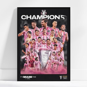 May include: A framed poster featuring a team of soccer players in pink jerseys, celebrating a championship. The word "CHAMPIONS" is prominently displayed at the top, with the text "IT'S MIAMI TIME" at the bottom. A trophy is in the center.