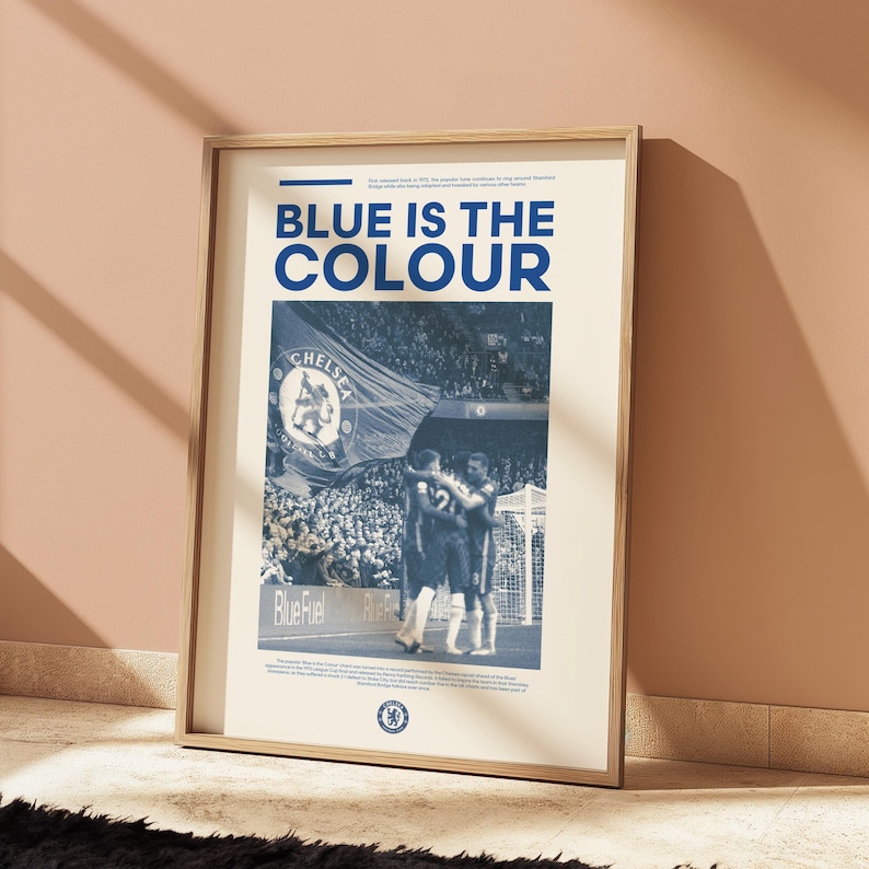 May include: A vintage-style poster with a blue and white color scheme featuring a photo of a soccer game. The poster has the text "BLUE IS THE COLOUR" and a Chelsea Football Club logo.
