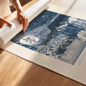 May include: A blue and white poster featuring a vintage photograph of a Chelsea Football Club match. The poster includes the Chelsea Football Club logo and the text "Bluebirds Rise".