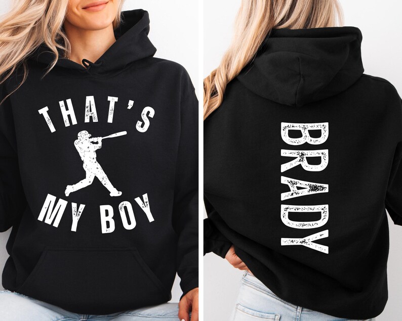 K&ouml;nnte beinhalten: Schwarzer Hoodie mit wei&szlig;em Text, der "That's My Boy" sagt, und einer Baseballspieler-Grafik auf der Vorderseite. Die R&uuml;ckseite des Hoodies hat wei&szlig;en Text, der "Brady" sagt.