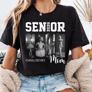Puede incluir: Una camiseta negra de manga corta con el texto blanco SENIOR 2026 en la parte superior. Debajo del texto hay cuatro paneles fotogr&aacute;ficos en blanco y negro de una bailarina. El nombre EMMA HENRY est&aacute; impreso a la izquierda y Mom a la derecha.