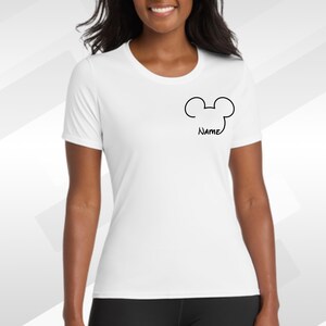 May include: White t-shirt with a black Mickey Mouse outline and the word "Name" below it. The shirt has a crew neck and short sleeves. The shirt is made of a soft, lightweight material.