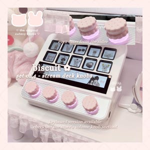 Könnte beinhalten: Ein weißes Stream Deck mit einem Satz von vier knopfartigen Keksen. Die Knöpfe sind rosa und weiß, mit einer beleuchteten Basis. Das Deck hat einen Bildschirm mit verschiedenen Symbolen und dem Text "biscuit set of 4 - stream deck knobs".