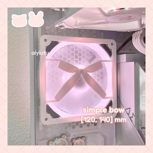 Puede incluir: Ventilador de ordenador blanco con diseño de lazo y patrón de panal. El ventilador tiene un brillo rosa y el texto "simple bow [120, 140] mm". El ventilador es parte de una caja de ordenador.