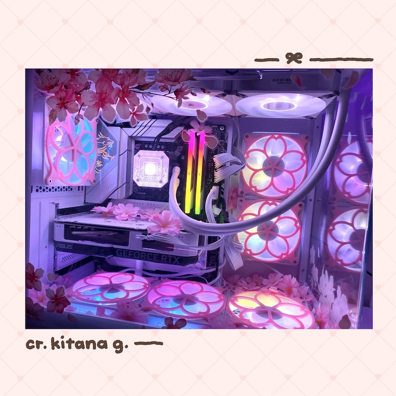 May include: A custom PC with a white case, decorated with pink and white floral elements. The internal components include a graphics card, fans with pink and white petal designs, and LED lighting. The text "cr. kitana g." is visible.