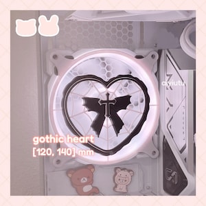 May include: A computer fan with a gothic heart design. The fan features a black heart shape with a cross and spiderweb design, surrounded by a white frame. The text "gothic heart [120, 140] mm" is visible.