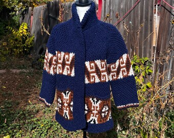 May include: A blue knitted cardigan with brown and white geometric patterns. The cardigan has a collar and pockets.
