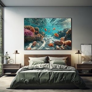 May include: A rectangular wall art print featuring an underwater scene with vibrant orange clownfish swimming near a colorful coral reef. The sandy ocean floor is visible with a bright orange starfish and various seashells resting on the seabed.