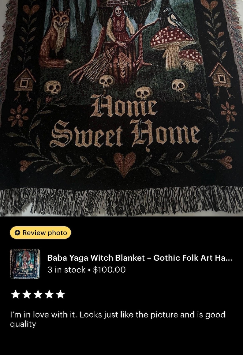 May include: A woven throw blanket featuring a dark forest scene with a central figure holding a broom, a fox, skulls, mushrooms, and two small houses on chicken legs. The text Home Sweet Home is centered in gothic font with a heart below the text.