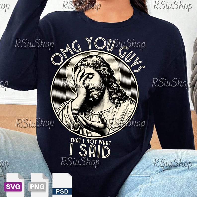 May include: Navy blue long-sleeve shirt featuring a graphic of Jesus with the text "OMG YOU GUYS THAT'S NOT WHAT I SAID". The graphic is in a circular design with a halo. The shirt is a crew neck.