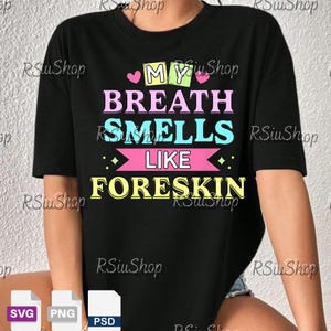 May include: Black t-shirt with the text "MY BREATH SMELLS LIKE FORESKIN" in colorful block letters. The design includes hearts and diamond shapes. The shirt is a casual wear item.