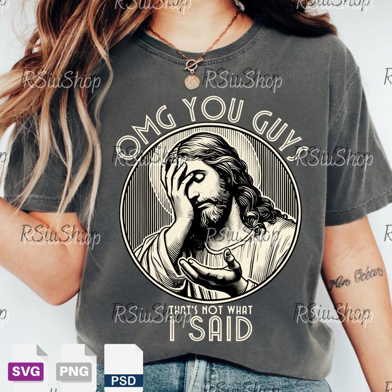 May include: Dark gray t-shirt featuring a distressed graphic of Jesus with his hand on his face, inside a circular frame. The text "OMG YOU GUYS" arches above the image, with "THAT'S NOT WHAT I SAID" below.