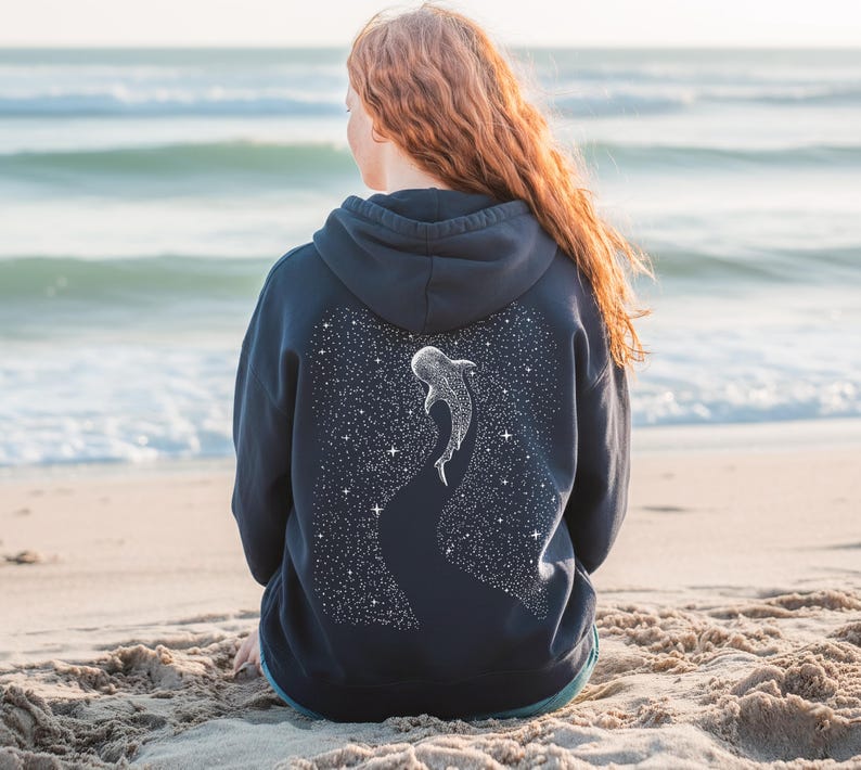 Pu&ograve; includere: Felpa con cappuccio blu navy con un design di squalo balena bianco sul retro. Il design include uno sfondo di cielo stellato. La felpa &egrave; realizzata in un materiale morbido ed &egrave; adatta per l'abbigliamento casual.