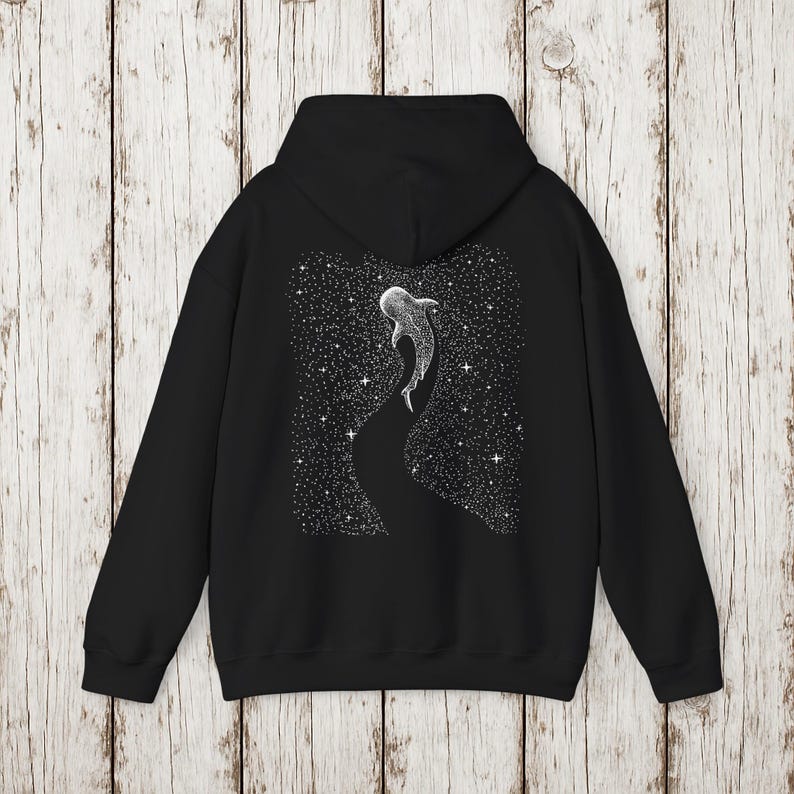 Pu&ograve; includere: Felpa con cappuccio nera con un'illustrazione bianca di uno squalo balena che nuota in un cielo stellato. Il disegno &egrave; sul retro. La felpa ha un cappuccio e maniche lunghe.