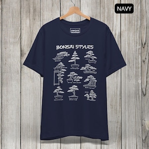May include: A navy blue t-shirt featuring a white graphic print titled Bonsai Styles. The design displays various bonsai tree shapes with labels including Windswept, Formal Upright, Leaning, Cascade, Semi-cascade, Raft, Informal Upright, Double Trunk, and Group.
