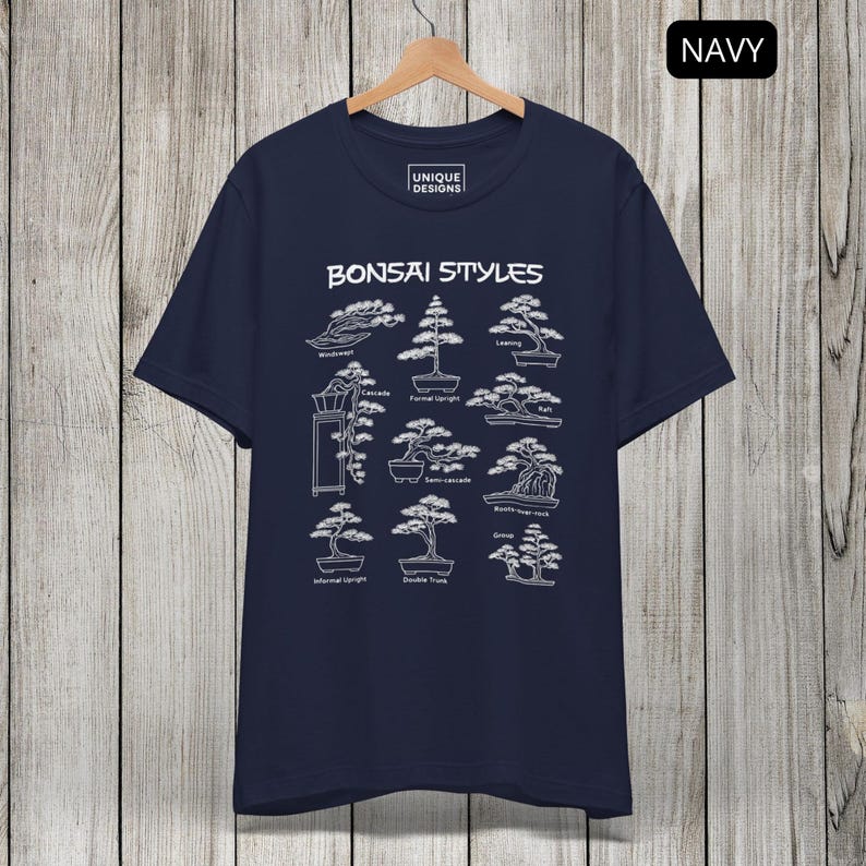 May include: A navy blue t-shirt featuring a white graphic print titled Bonsai Styles. The design displays various bonsai tree shapes with labels including Windswept, Formal Upright, Leaning, Cascade, Semi-cascade, Raft, Informal Upright, Double Trunk, and Group.