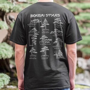 May include: A black t-shirt featuring a white graphic on the back titled Bonsai Styles. The print displays nine distinct tree shapes with labels including Windswept, Cascade, Formal Upright, Leaning, Raft, Semi-cascade, Root-over-rock, Informal Upright, and Double Trunk.