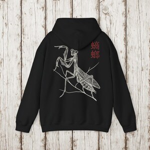 May include: Black hoodie featuring a detailed white illustration of a praying mantis on a branch. The design includes the Chinese characters for mantis in red. The hoodie has a hood and long sleeves, perfect for casual wear.