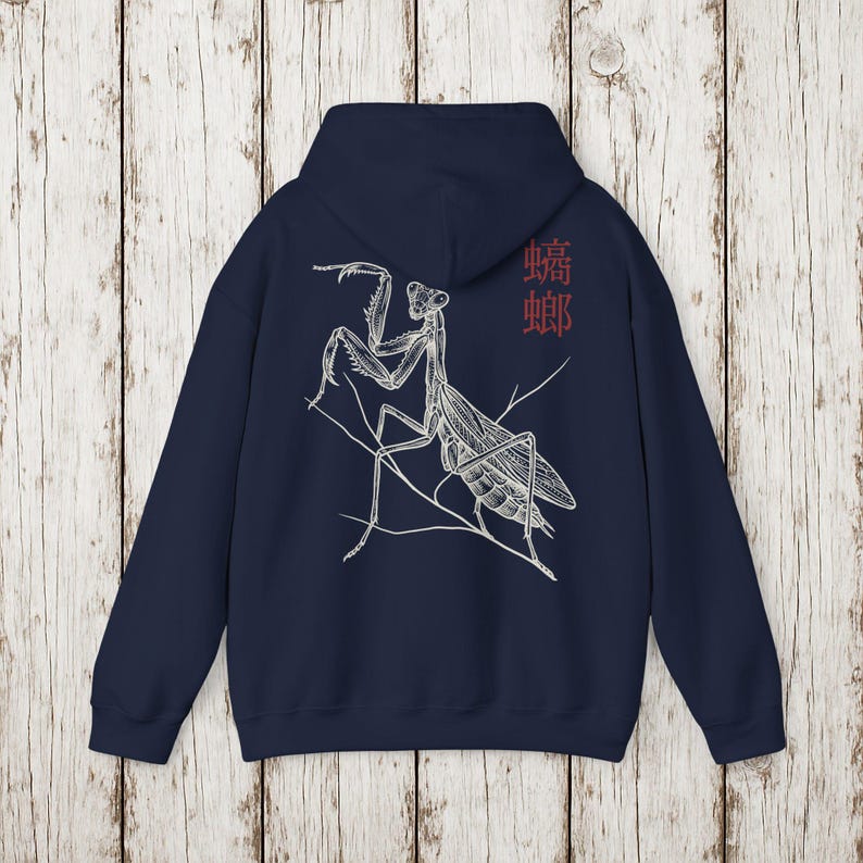 May include: Navy blue hoodie featuring a detailed white illustration of a praying mantis on the back. The design includes the Japanese characters for mantis in red. The hoodie has a drawstring hood and a kangaroo pocket.