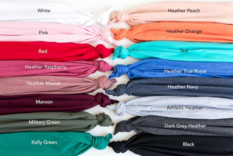 May include: A collection of folded fabric samples in various colors, including white, pink, red, and black. Other colors include heather peach, orange, teal, and true royal. Each sample is labeled with its color name.