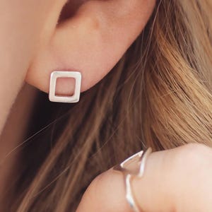 Matte silver stud earrings worn, everyday earrings