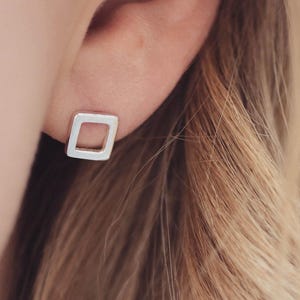 Square earrings worn in matte finish, minimal earrings