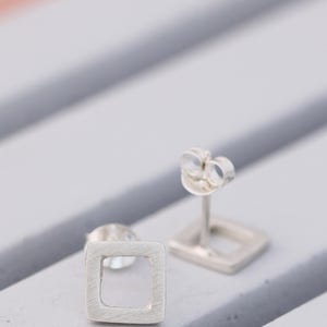 quare stud earrings in matte silver showing post and scroll backs