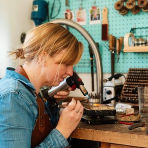 Jeweller Louy Magroos handcrafting geometric earrings at a workbench. Handmade earrings designed for modern jewellery lovers.