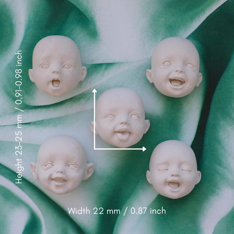 May include: Five small, off-white doll heads with various facial expressions, including open mouths, closed eyes, and tongues sticking out. The heads are approximately 0.91-0.98 inches tall and 0.87 inches wide. They are arranged on a green and white patterned background.
