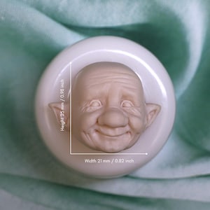May include: A white silicone mold for making a gnome face. The mold is 0.98 inches tall and 0.82 inches wide.