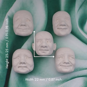 Può includere: Cinque piccoli volti umani scolpiti, bianco sporco, con espressioni diverse. I volti misurano 23-25 mm di altezza e 22 mm di larghezza. I volti hanno tratti dettagliati, tra cui occhi, nasi e bocche.