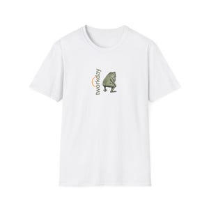 May include: White t-shirt featuring a cartoon frog graphic and the text "tworkday" in orange and black. The frog is depicted in a seated position. The shirt has a crew neck and short sleeves.