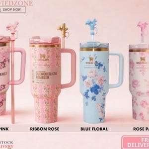 Puede incluir: Cuatro vasos Stanley Quencher H2.0 con asas y pajitas. El primero es rosa floral, el segundo es rosa cinta con rayas, el tercero es azul floral y el cuarto es blanco con un patr&oacute;n de rosas. Cada uno cuenta con una tapa y un logotipo.
