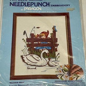 May include: Needlepoint embroidery kit featuring a Hummel "Mother Swan" design. The kit includes a white Aida cloth, needlepoint yarn, and instructions. The finished size is 8 inches by 10 inches.