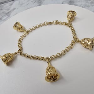 pulso de oshun com 5 campanas laminadas em pulseira oro-oshun com 5 sinos banhados a ouro