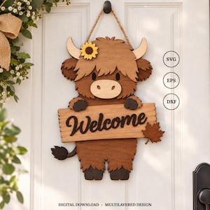 Puede incluir: Un adorno de pared de madera en capas que muestra una vaca Highland marrón con un girasol amarillo en la cabeza, sosteniendo un letrero que dice Welcome con una hoja de arce. El diseño incluye etiquetas SVG, EPS y DXF para descarga digital.